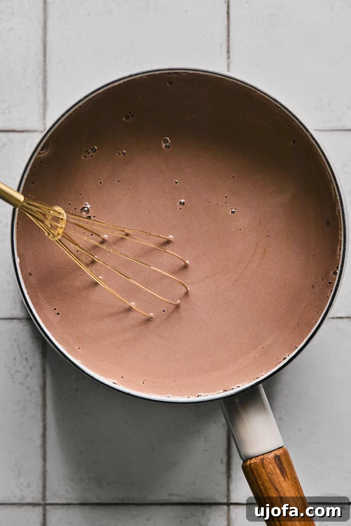 Cozy Protein-Packed Cocoa 5 The protein hot chocolate mixture simmering gently in a saucepan, fully combined and emitting steam, indicating readiness.