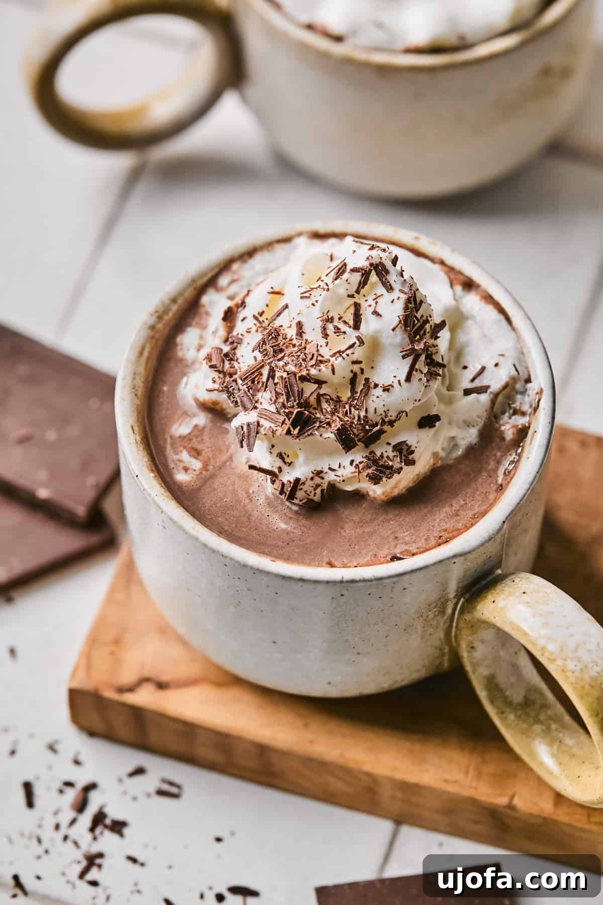 Cozy Protein-Packed Cocoa 6 Close-up of a steaming mug of protein hot chocolate, richly topped with whipped cream and fine chocolate shavings, highlighting its inviting warmth and texture.