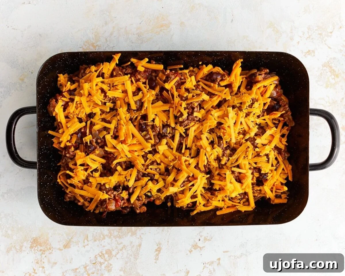 Unbagged Taco Bake 8 Layering the corn chips, beef mixture, and cheese in a baking dish.