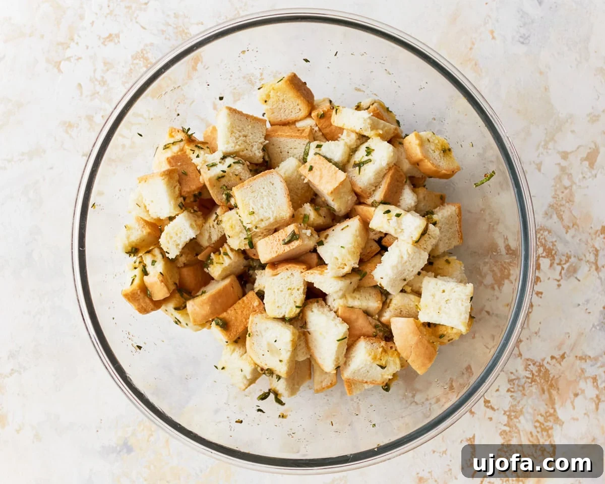 Flavorful Gluten-Free Stuffing 10 Bread cubes and seasoning in a glass mixing bowl for gluten-free stuffing recipe