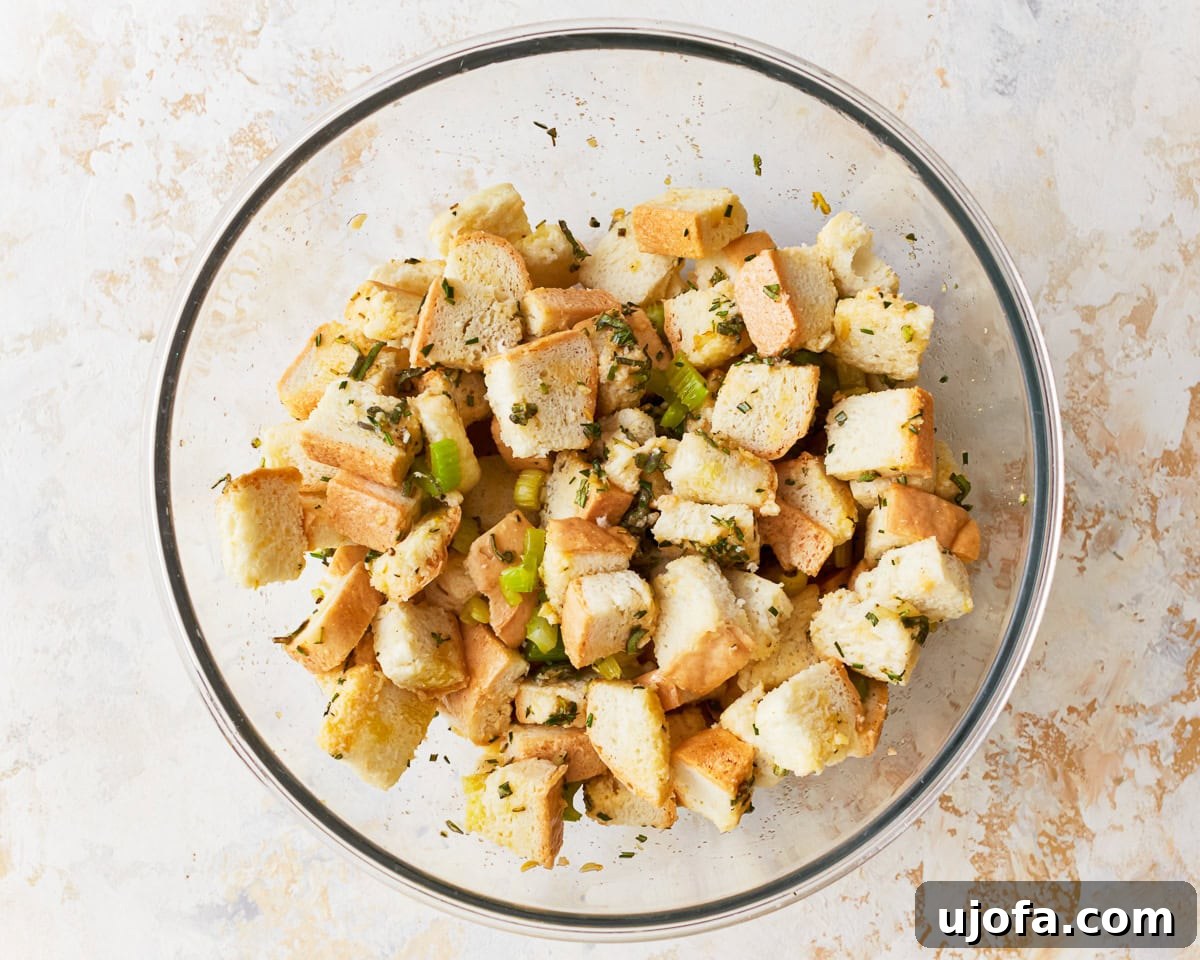 Flavorful Gluten-Free Stuffing 11 Bread cubes, seasoning, and celery in a glass mixing bowl for gluten-free stuffing recipe