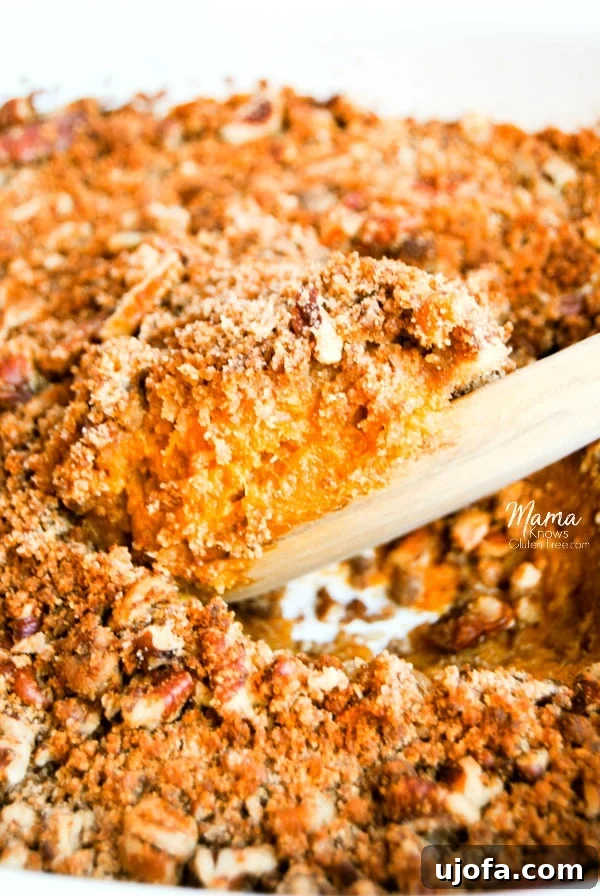 Closeup of Paleo Sweet Potato Casserole with a generous pecan topping, ready to be served.