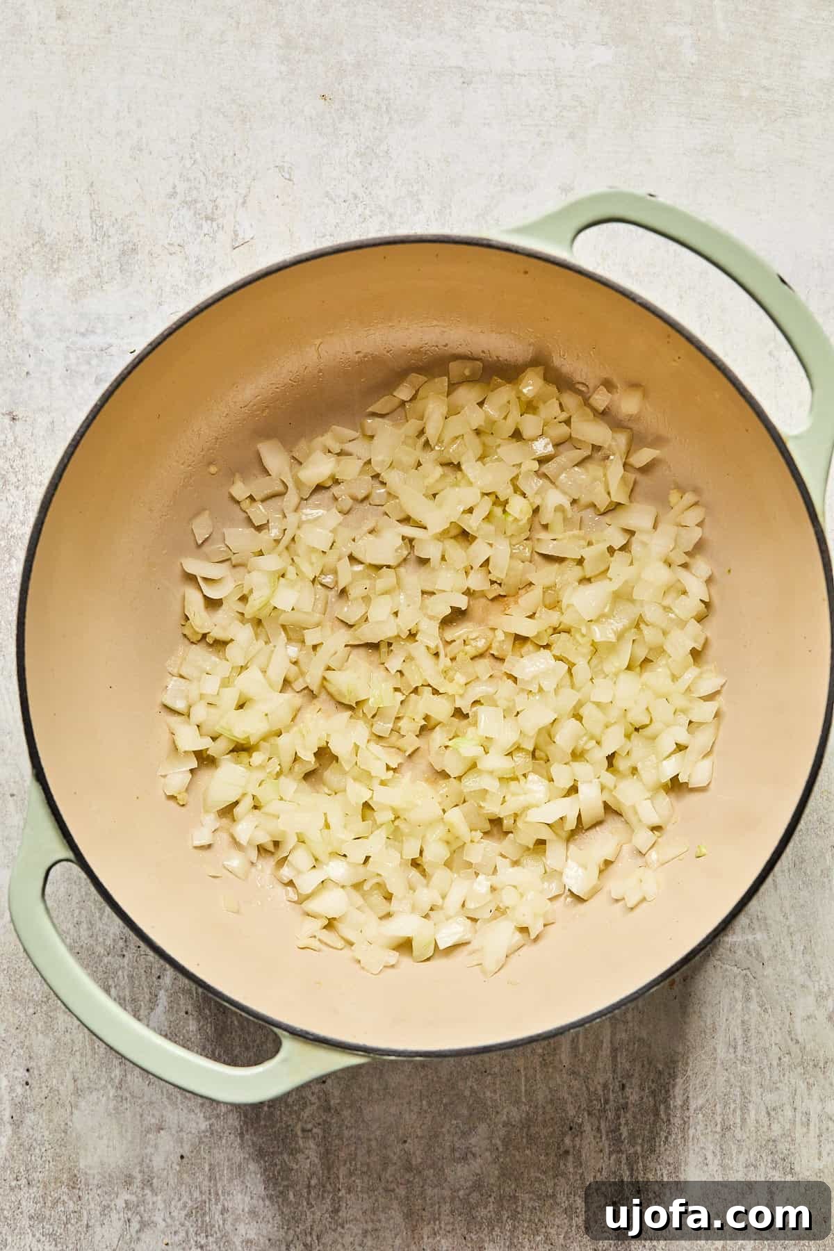 Diced onions and minced garlic gently sizzling in olive oil within the pot, becoming fragrant and translucent.