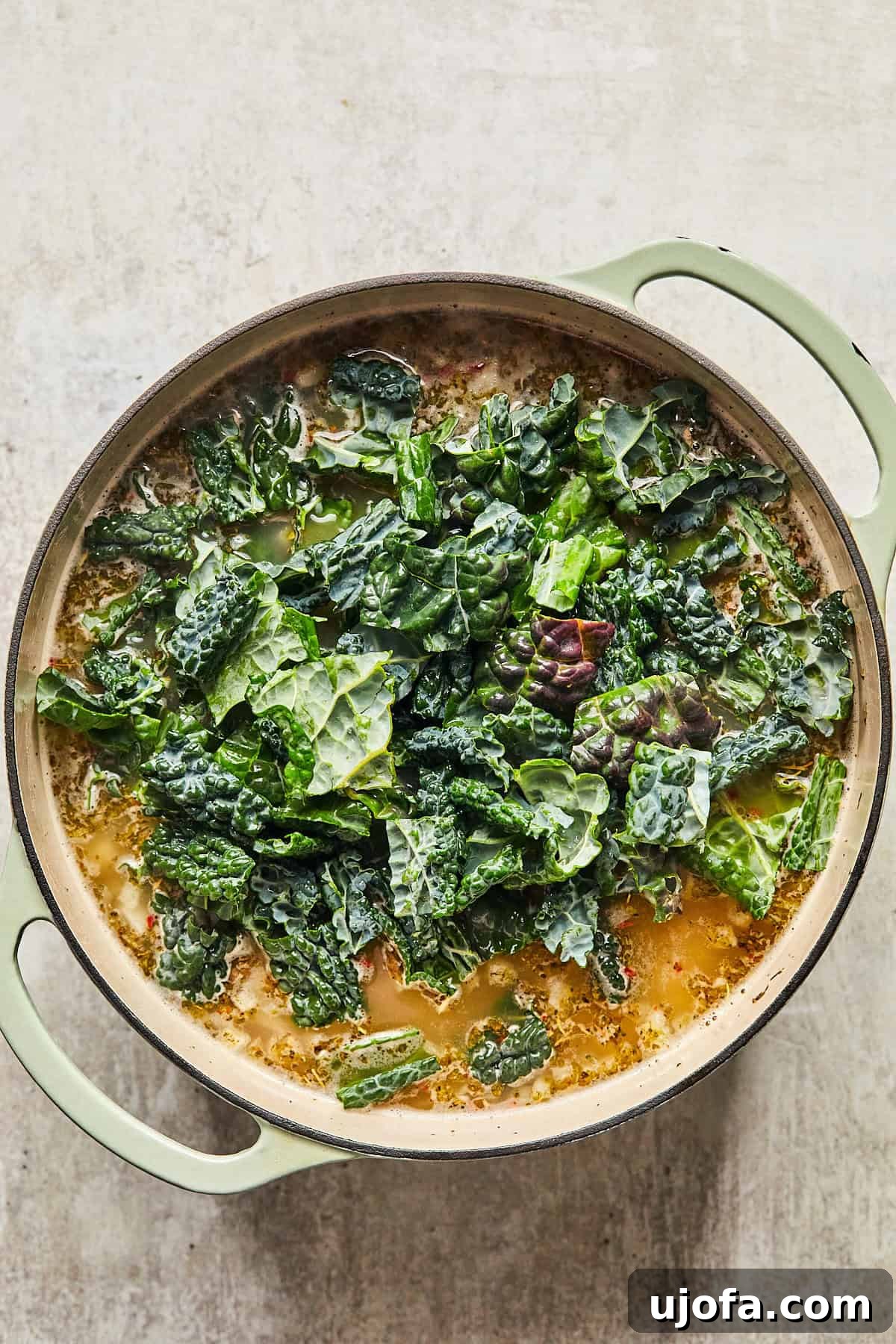 Fresh kale leaves added to the simmering soup, wilting beautifully into the rich broth with beans and turkey.
