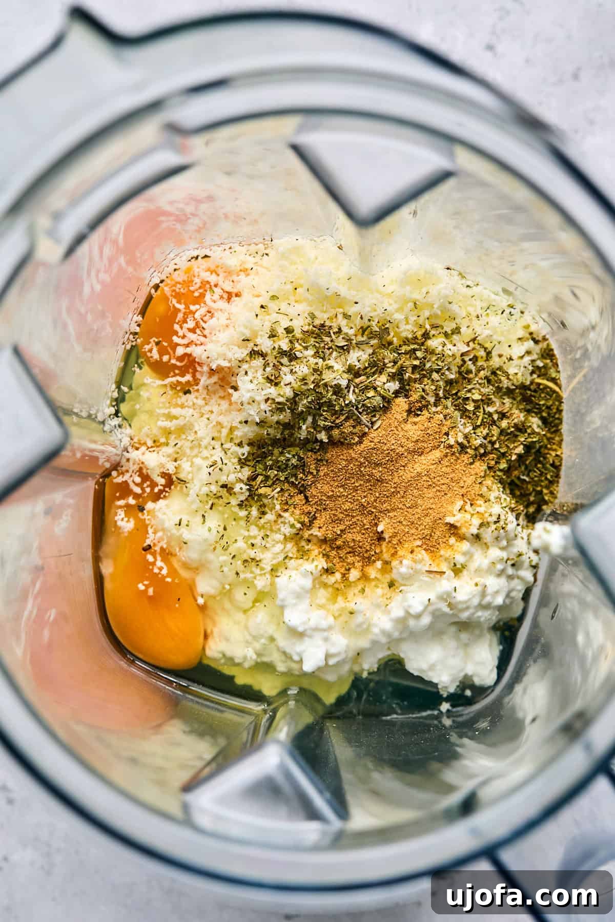 High Protein Cottage Cheese Flatbread Gluten Free Flourless 4 Cottage cheese, eggs, and various spices being added to a blender for the flatbread batter.