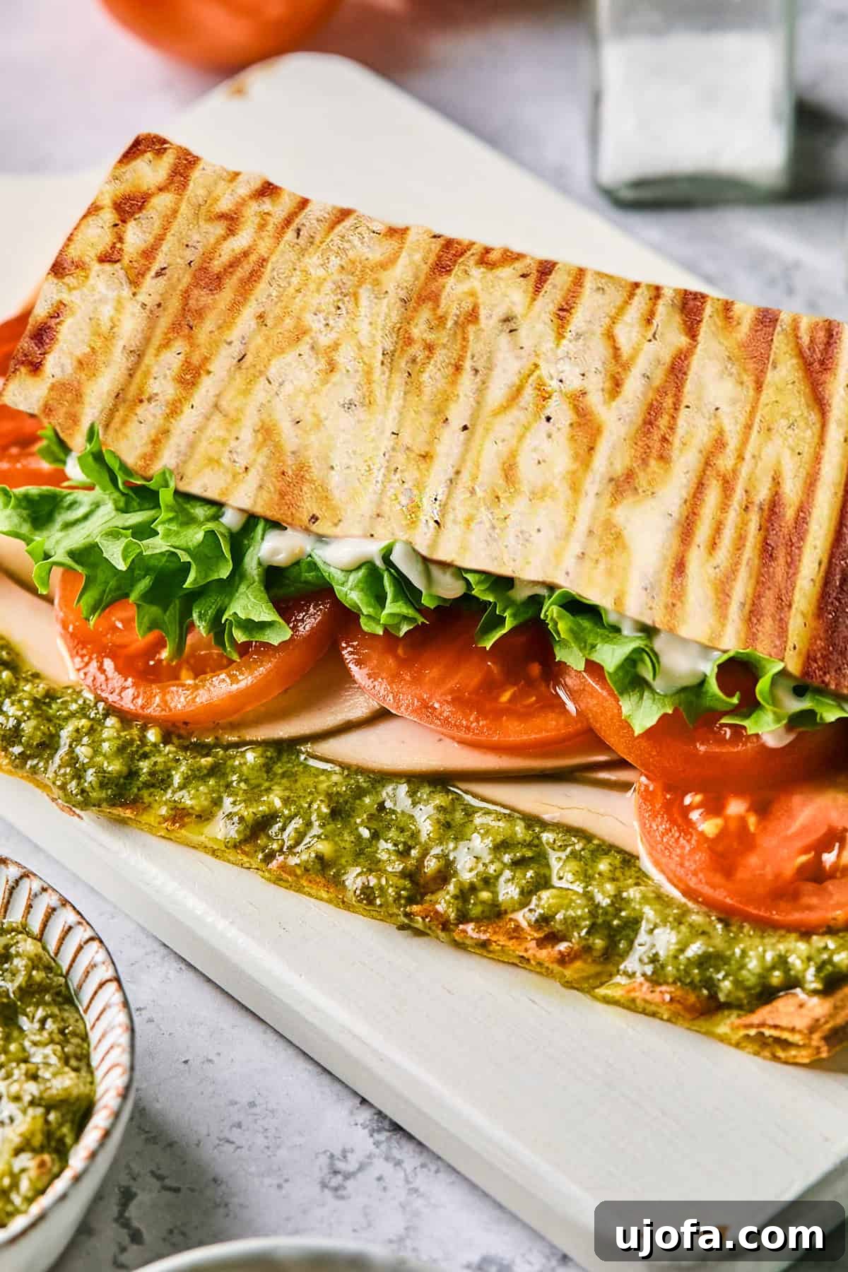 High Protein Cottage Cheese Flatbread Gluten Free Flourless 9 A close-up side view of a cottage cheese flatbread sandwich revealing layers of crisp lettuce, juicy tomato slices, tender turkey, and creamy pesto.