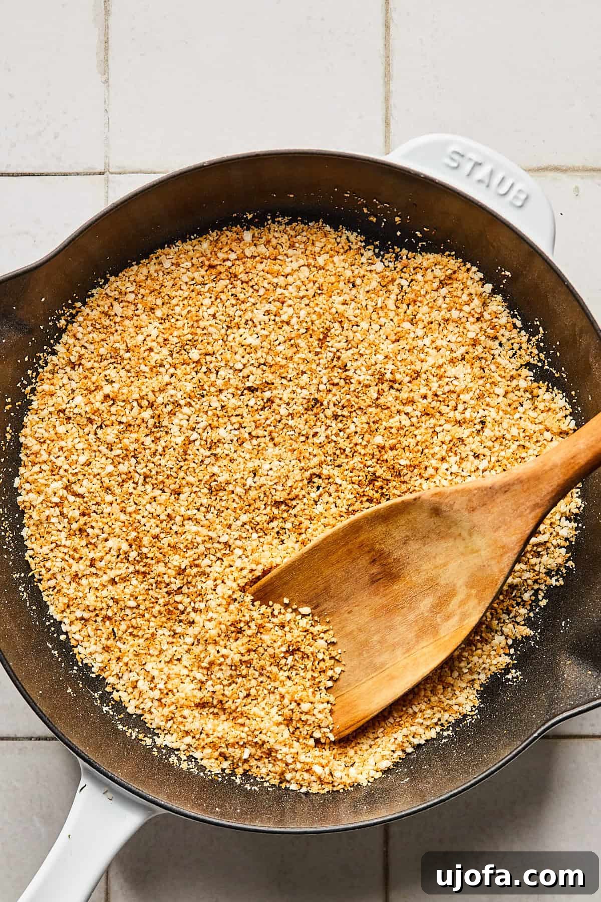breadcrumbs in a cast iron pan with a wooden spoon
