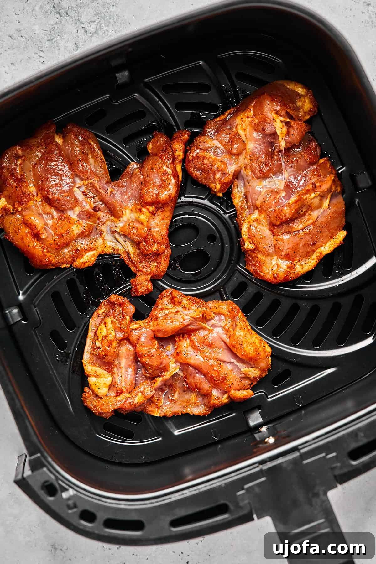 Crispy Juicy Air Fryer Boneless Thighs 8 raw chicken arranged on an air fryer