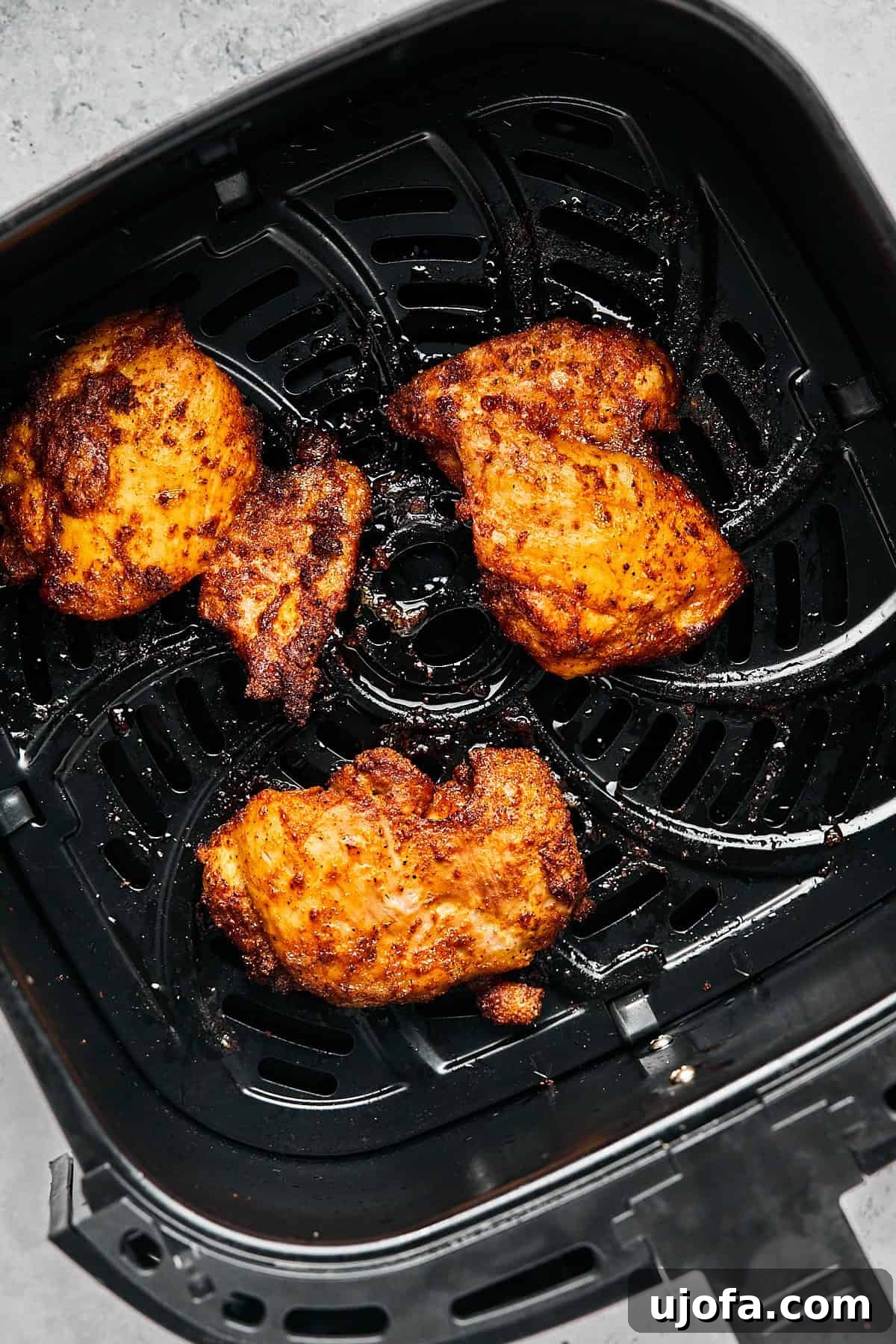 Crispy Juicy Air Fryer Boneless Thighs 9 chicken cooked and resting in an air fryer