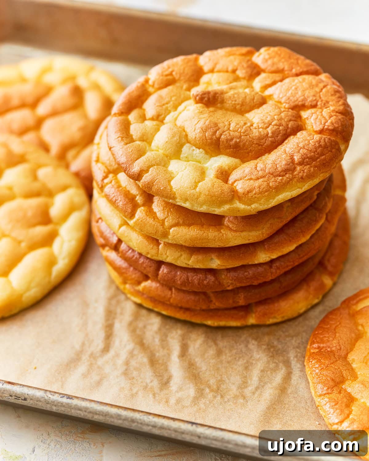 Fluffy Cloud Bread 2 A stack of cloud bread on a parchment lined baking sheet.