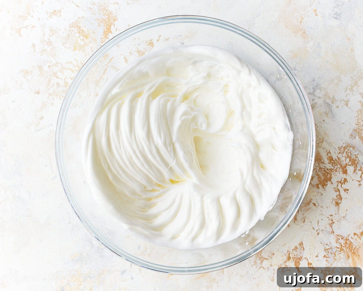 Fluffy Cloud Bread 4 Whipped egg whites for cloud bread in a glass mixing bowl.