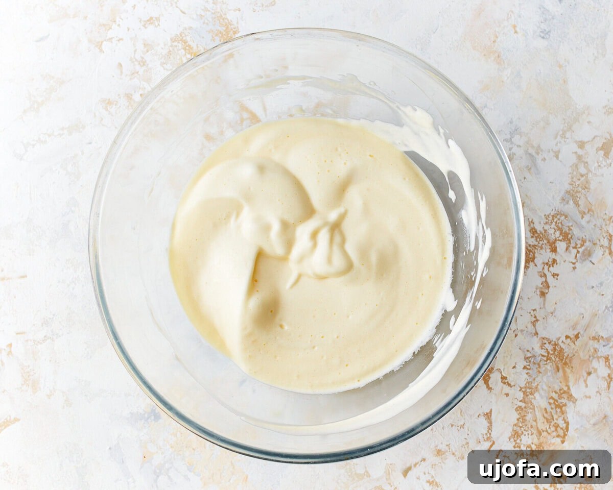 Fluffy Cloud Bread 6 Egg white and cream cheese mixture for cloud bread in a glass mixing bowl.