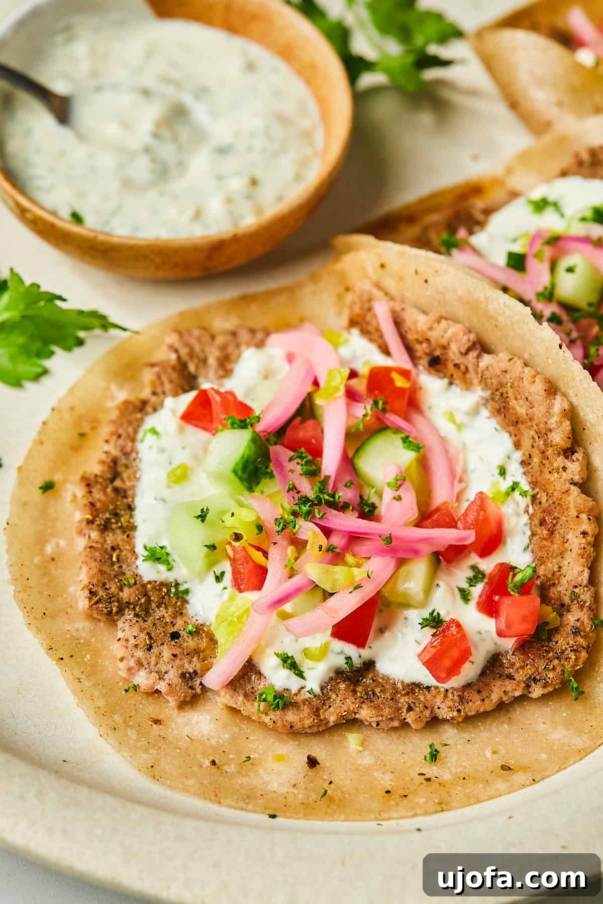 Turkey Gyro Smash Tacos 11 An open-faced turkey smash burger taco topped with dill yogurt sauce, pickled onions, tomatoes, and cucumbers