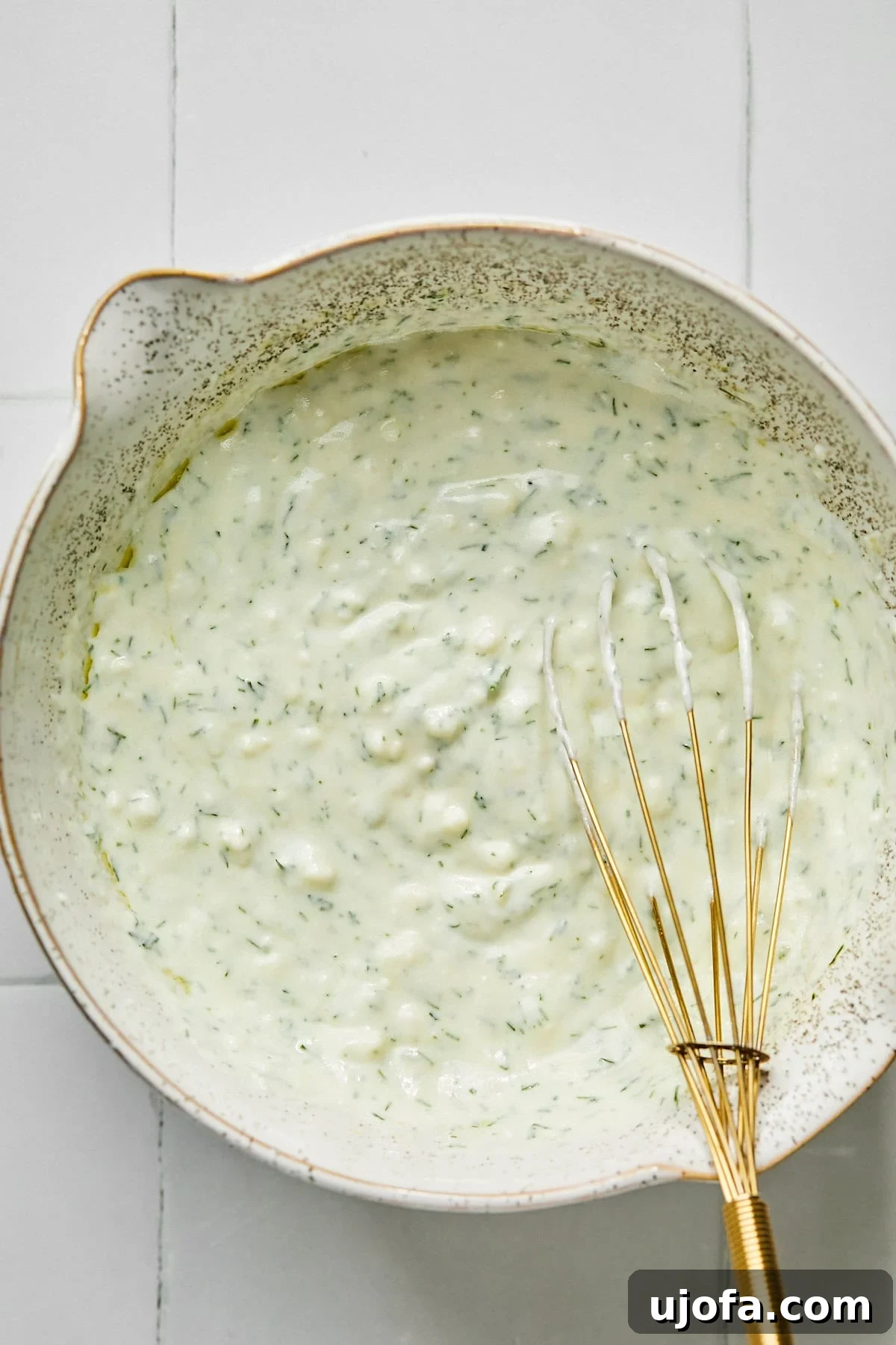 Turkey Gyro Smash Tacos 5 Dill yogurt sauce being whisked with a gold whisk