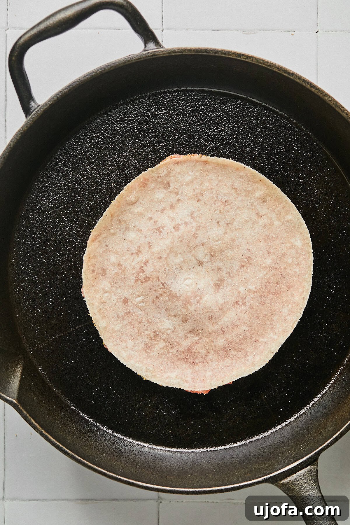Turkey Gyro Smash Tacos 9 A turkey smash burger taco cooking meat-side down in a cast iron pan