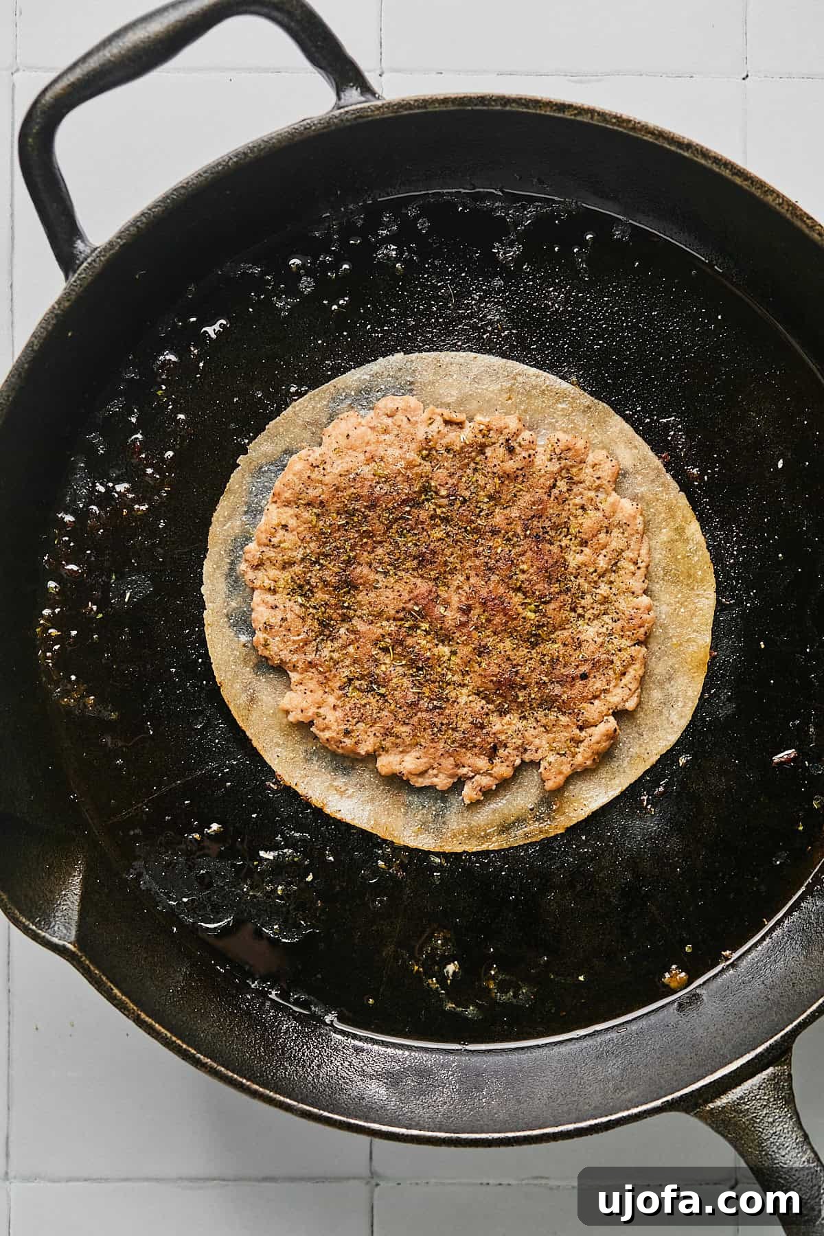 Turkey Gyro Smash Tacos 10 A turkey smash burger taco being flipped in a cast iron pan
