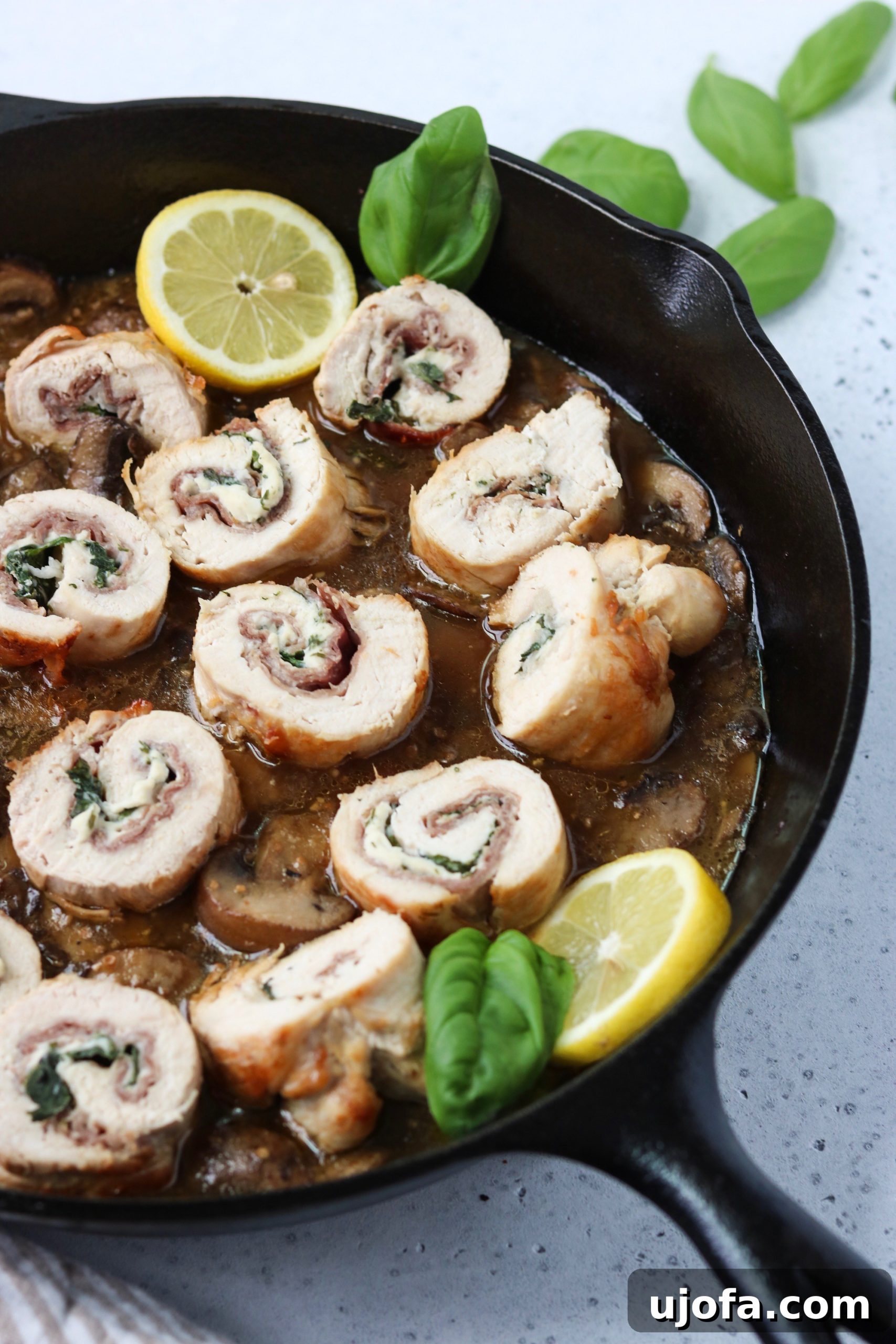 Another angle of the prosciutto basil stuffed chicken, showcasing the golden crust and the creamy filling peeking out.