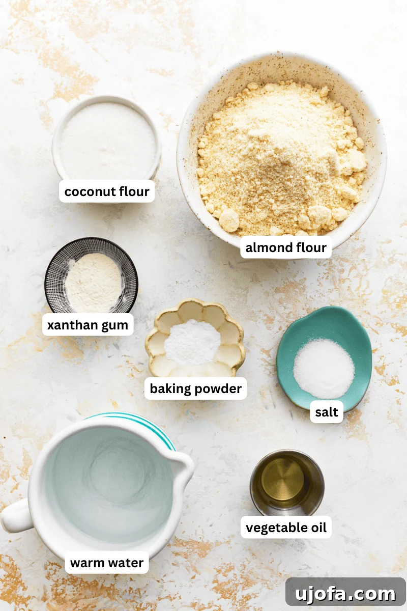 A selection of ingredients for almond flour tortillas laid out, including flours, gum, and oil.