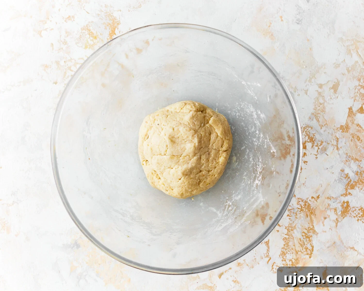 Dough for almond flour tortillas in a glass mixing bowl, just after mixing.