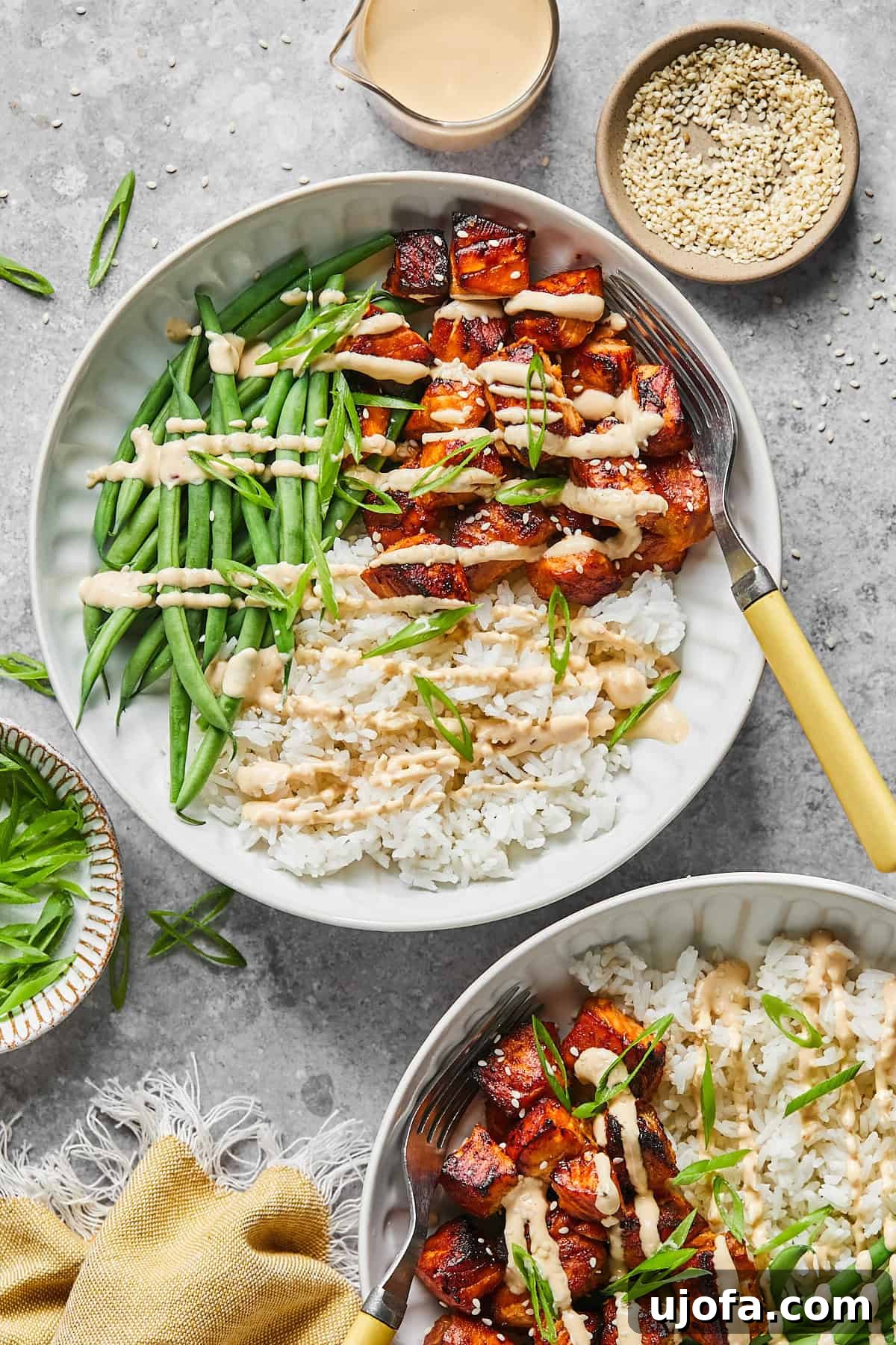 2 salmon bite bowls with rice and green beans and sauce 