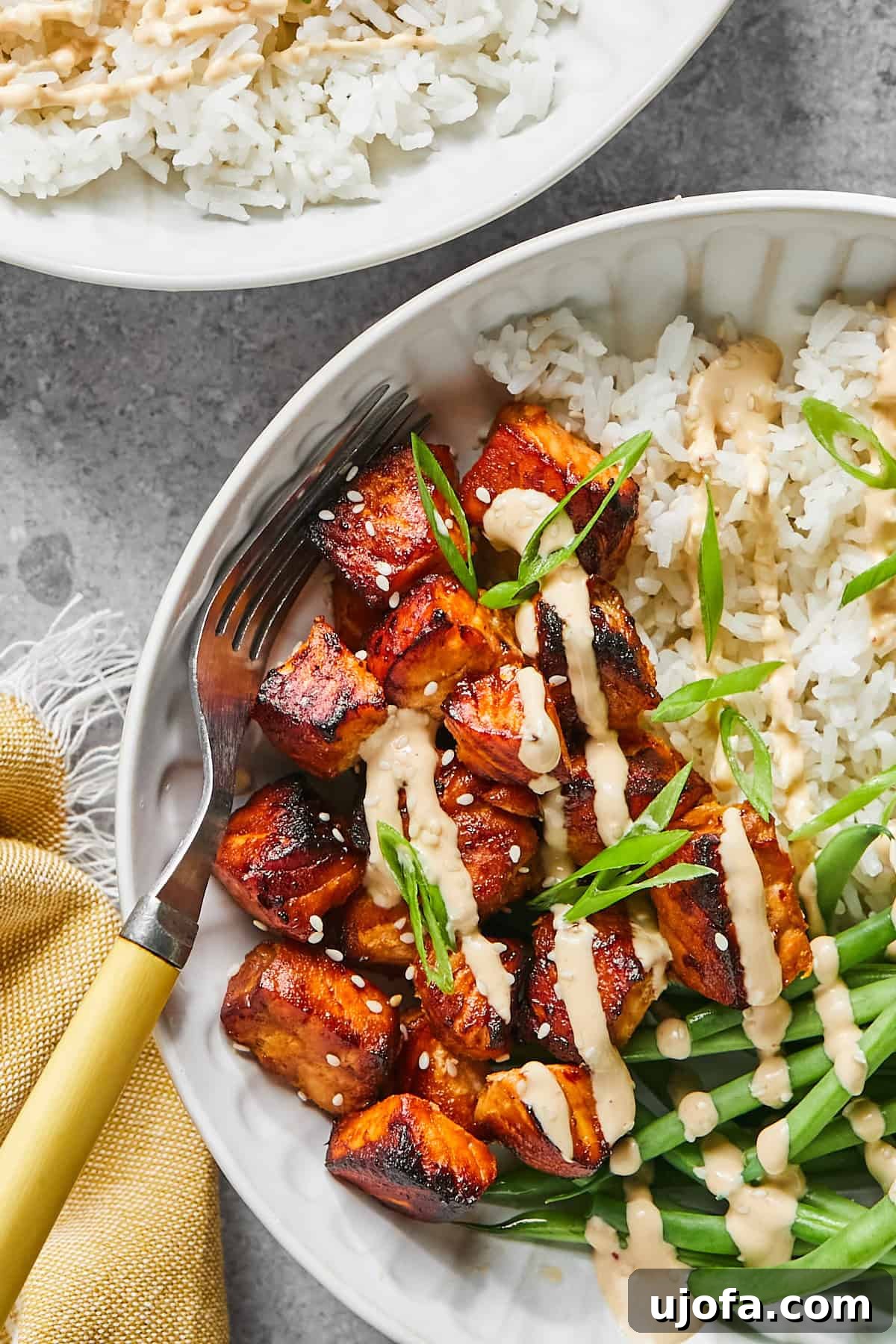 a close up of bang bang salmon bites with sauce
