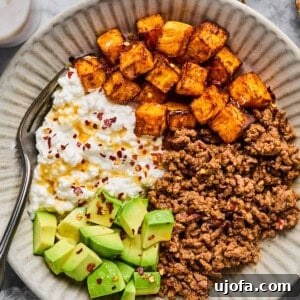 A high-protein Cottage Cheese Taco Bowl with seasoned ground beef, cottage cheese, sweet potatoes, avocado, and hot honey.