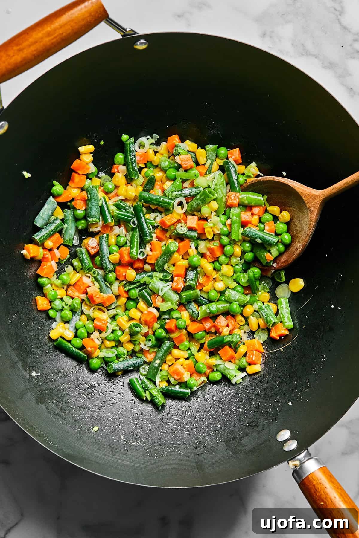 Frozen mixed vegetables added to the skillet with sautéed aromatics