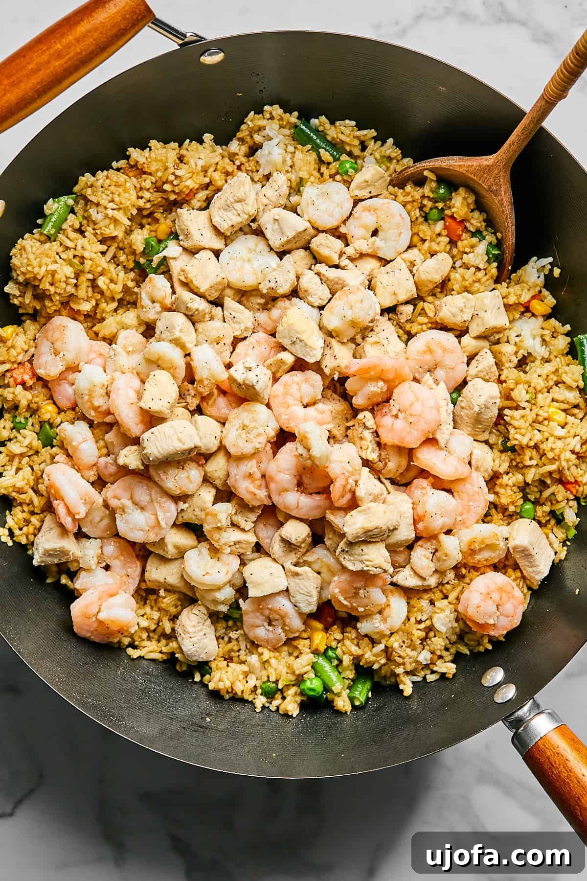 Cooked chicken and shrimp returned to the skillet with rice