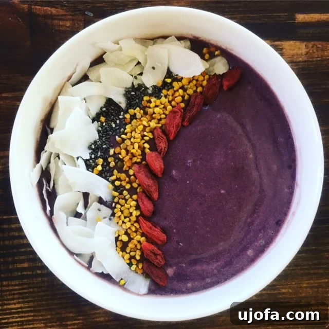 Vibrant purple acai smoothie bowl topped with fresh berries, coconut flakes, and chia seeds.