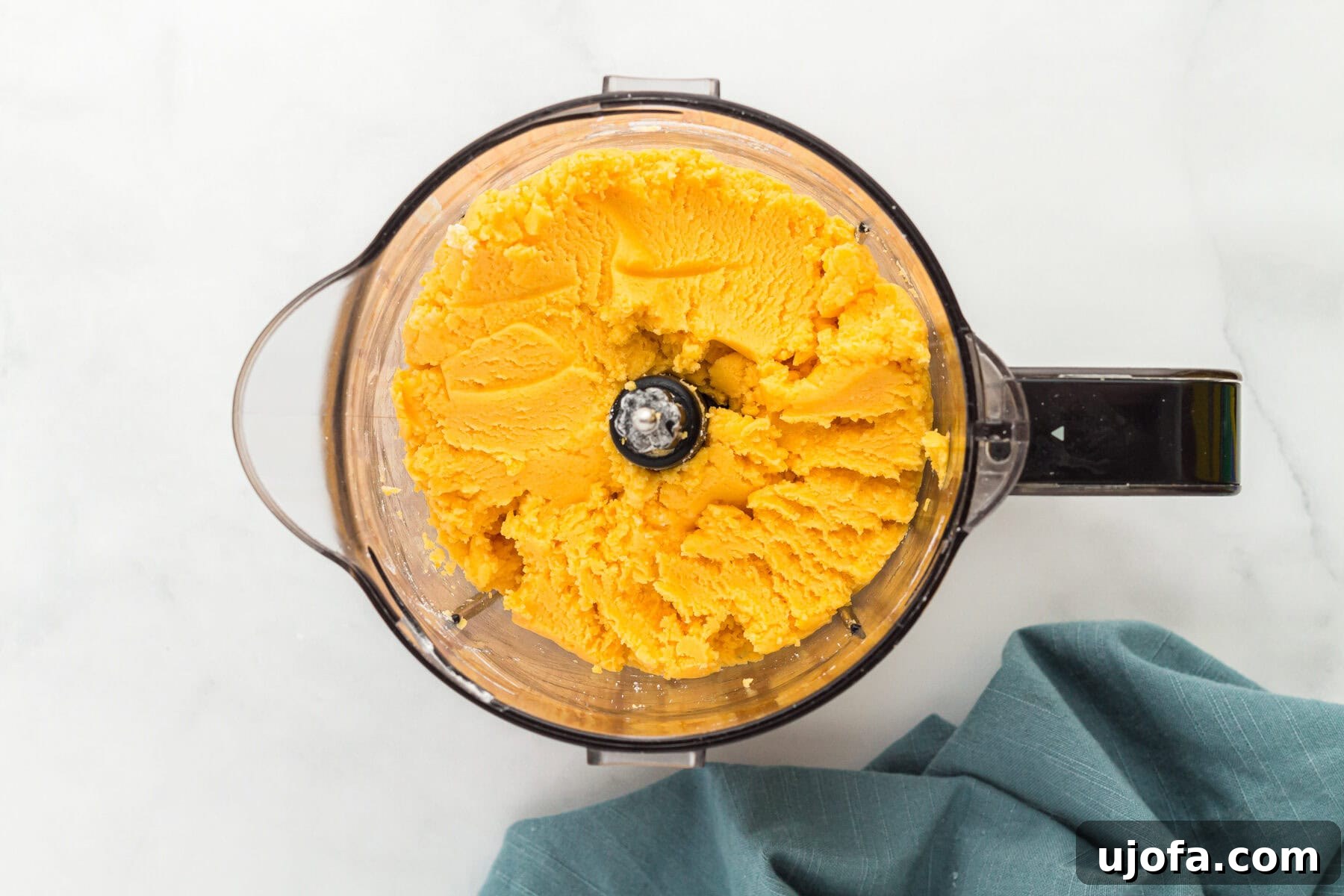 Gluten-free Cheez-Its dough starting to form in a blender after adding water.