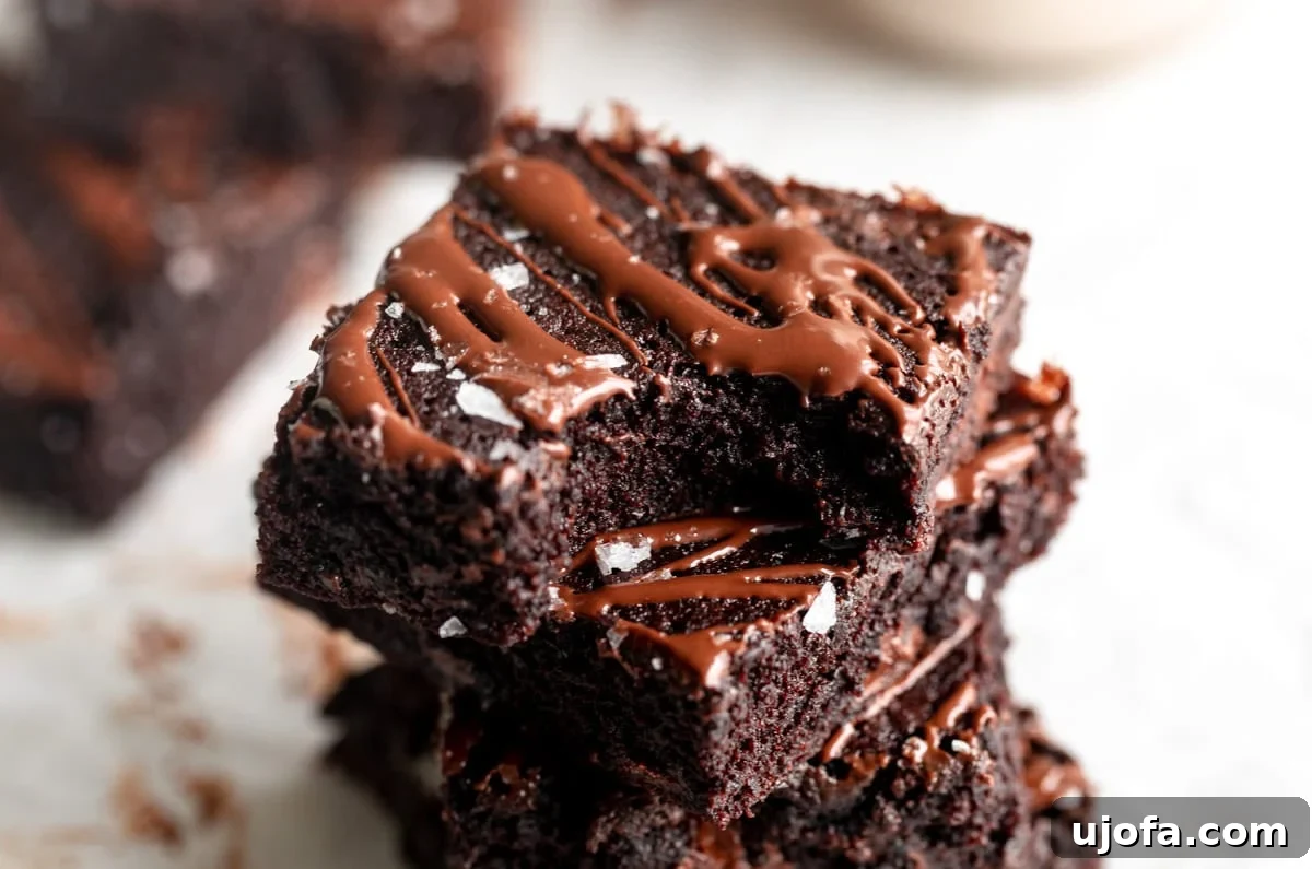 Fudgy Coconut Flour Brownies 4 A stack of coconut flour brownies, showcasing their rich color and fudgy texture on a white background.