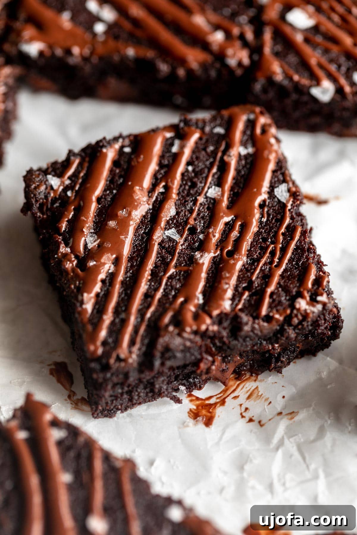 Fudgy Coconut Flour Brownies 5 Coconut flour brownies cooling on parchment paper after being baked, with a rustic, home-baked appearance.