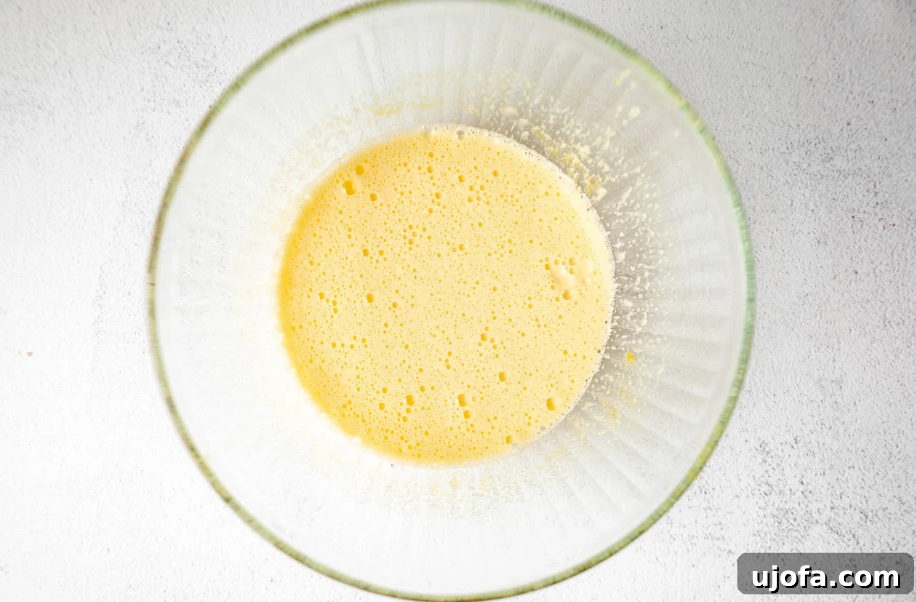 Fudgy Coconut Flour Brownies 7 Whisked eggs and sugar for coconut flour brownies in a glass mixing bowl, light yellow and frothy.