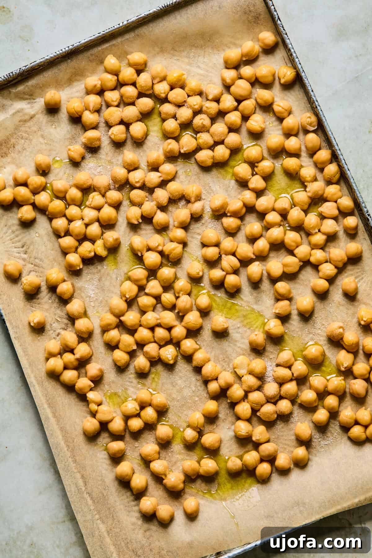 step 1: raw chickpeas spread on a baking sheet before roasting
