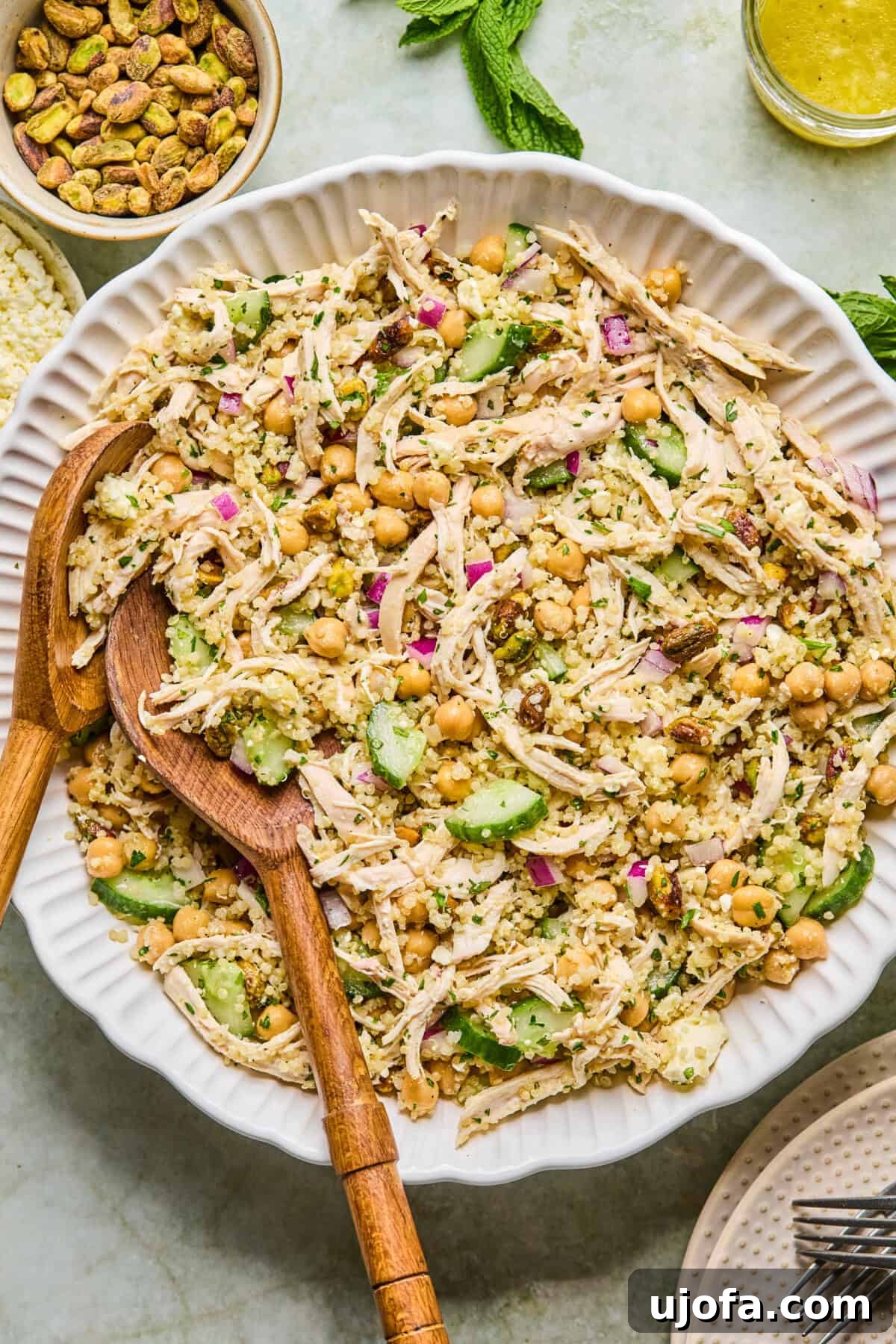 Jennifer Aniston Protein Power Prep Salad 6 Step 3: Pouring the freshly prepared lemon dressing over the tossed quinoa and chicken salad, ensuring every ingredient gets coated.