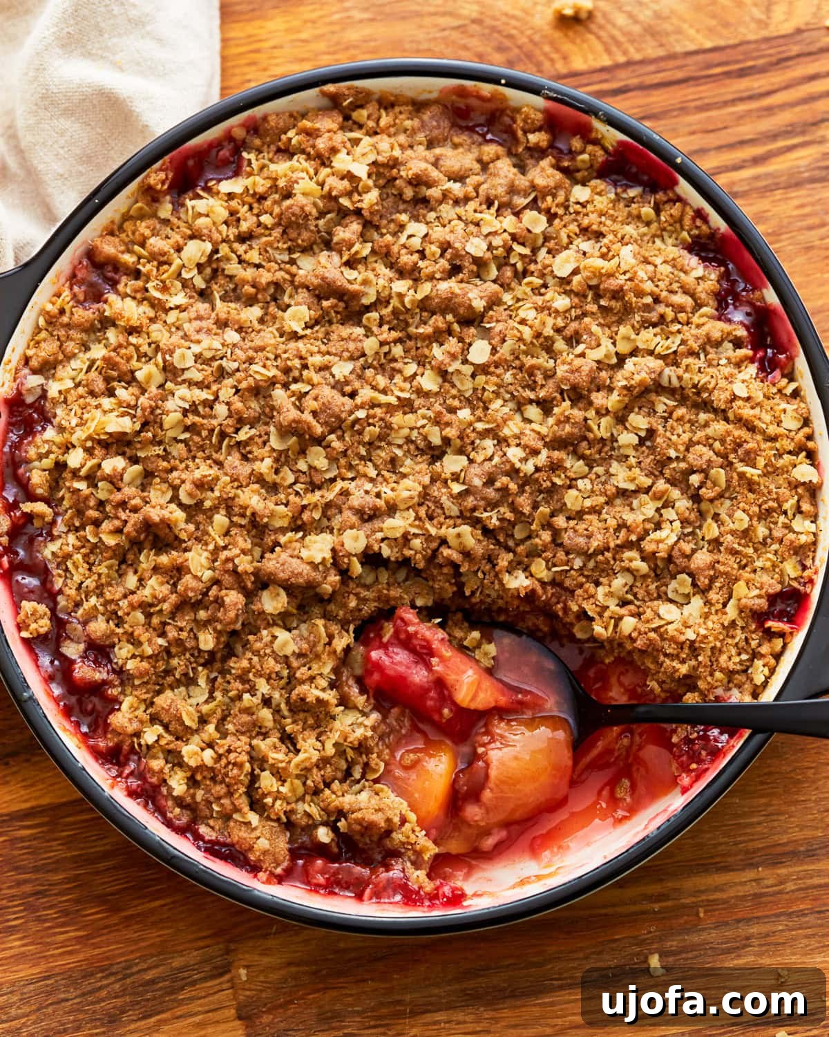 Golden Gluten-Free Peach Crisp 2 Gluten-free peach crisp in a baking dish with a spoon