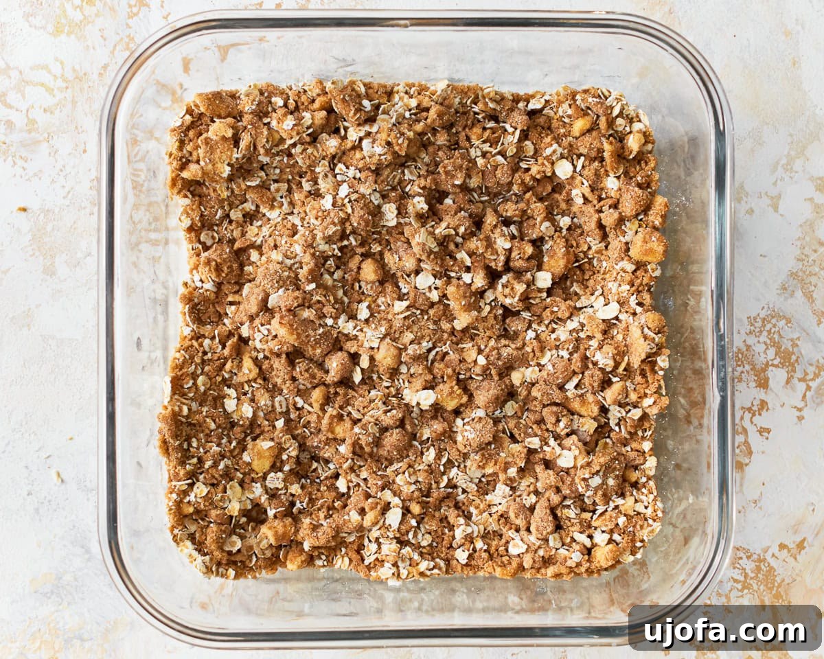 Golden Gluten-Free Peach Crisp 10 Oats mixed into the crisp for gluten-free peach crisp in a glass baking dish.