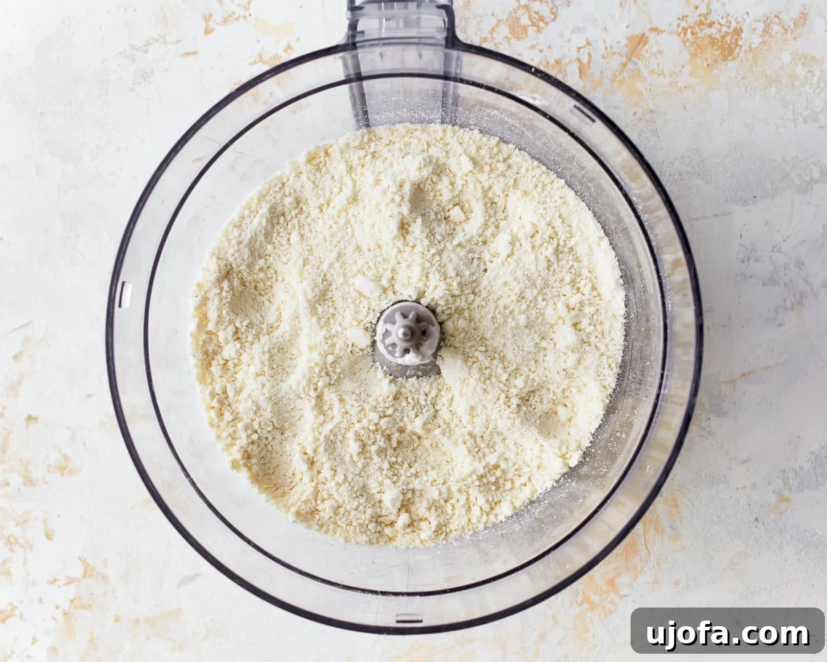 Golden Pandebono Colombian Bakery Classic 6 Feta cheese, masa harina corn flour, and tapioca starch in a food processor bowl, ready to be pulsed.