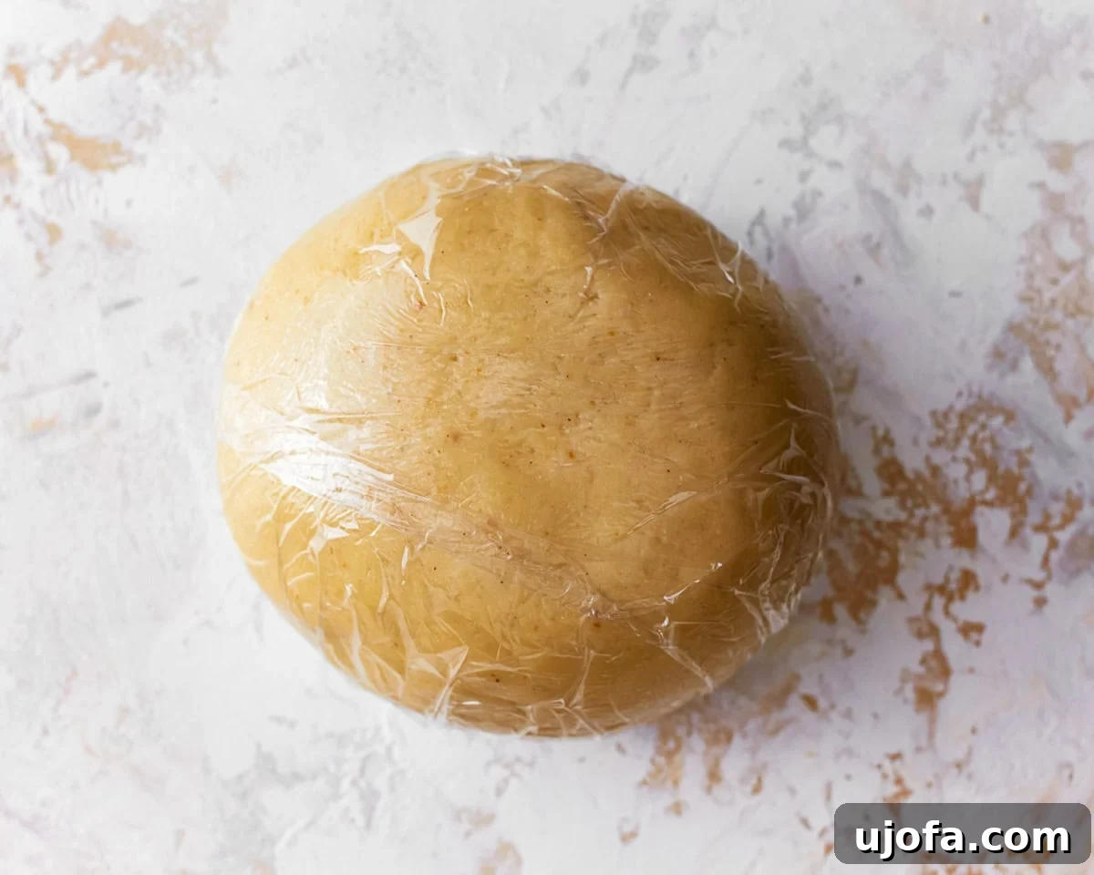 A ball of almond flour pasta dough wrapped in plastic wrap