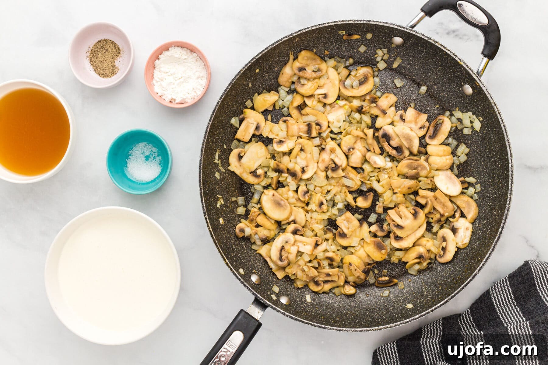 Sliced onions, mushrooms, and garlic in a skillet