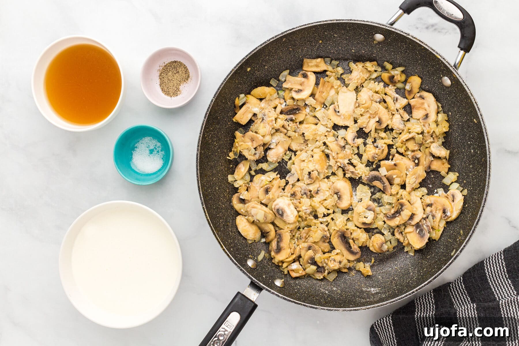 Mushrooms and onions coated in gluten-free flour in a skillet for the filling for gluten-free tuna casserole
