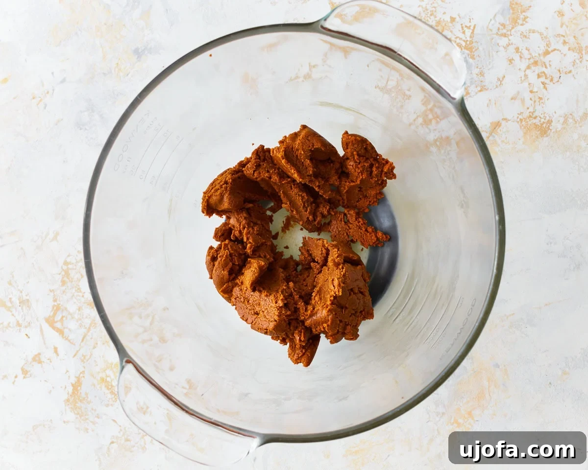 Peanut butter, brown sugar, and vanilla combined in a mixing bowl, showing the initial creamy mixture for gluten-free cookies.
