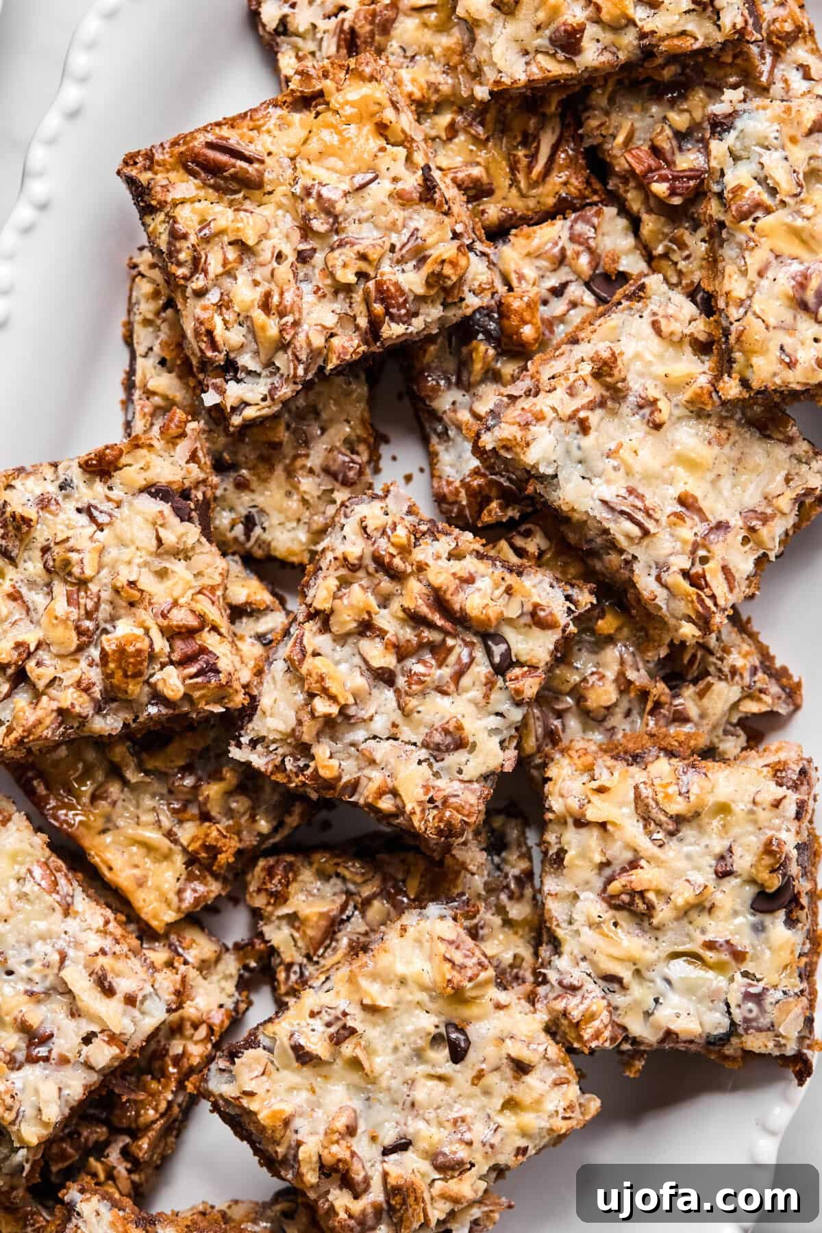 Wondrously Easy Allergen Friendly Bars 2 Golden-baked gluten-free magic bars sliced into squares on a wire cooling rack with toasted coconut and chocolate chips visible, showcasing their layered goodness.