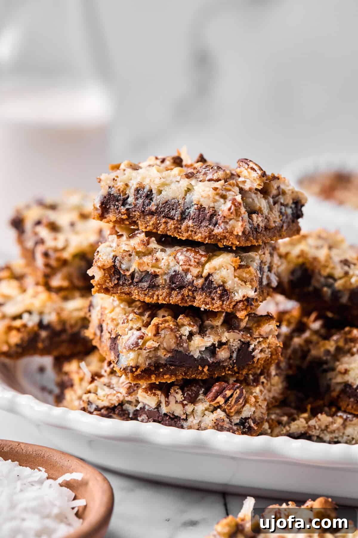 Wondrously Easy Allergen Friendly Bars 11 Close-up of a stack of gluten-free magic bar squares showing defined layers of chocolate, coconut, and pecans, highlighting the rich texture.