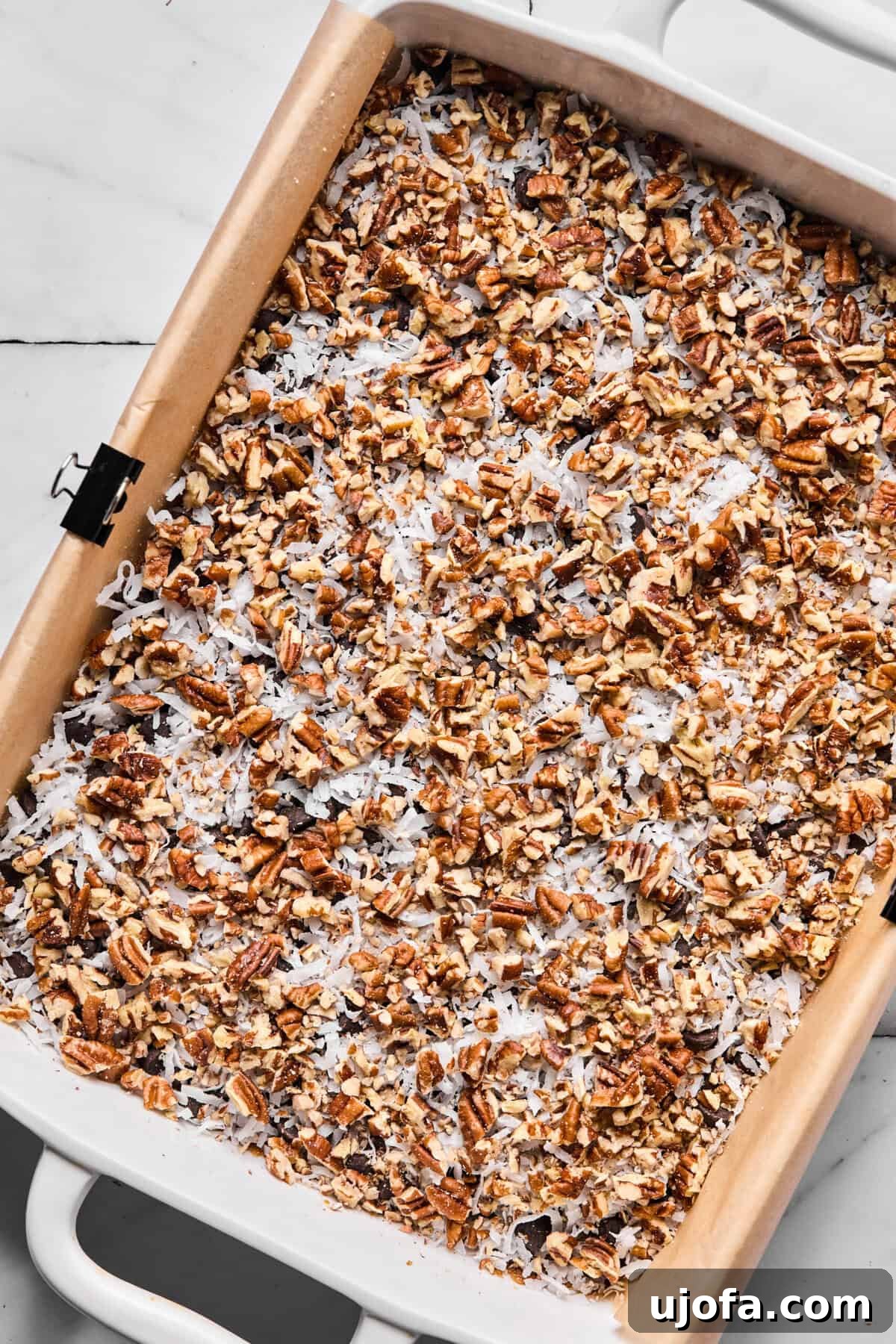 Wondrously Easy Allergen Friendly Bars 7 Chopped pecans and coconut flakes sprinkled over chocolate chip layer, completing the dry toppings.