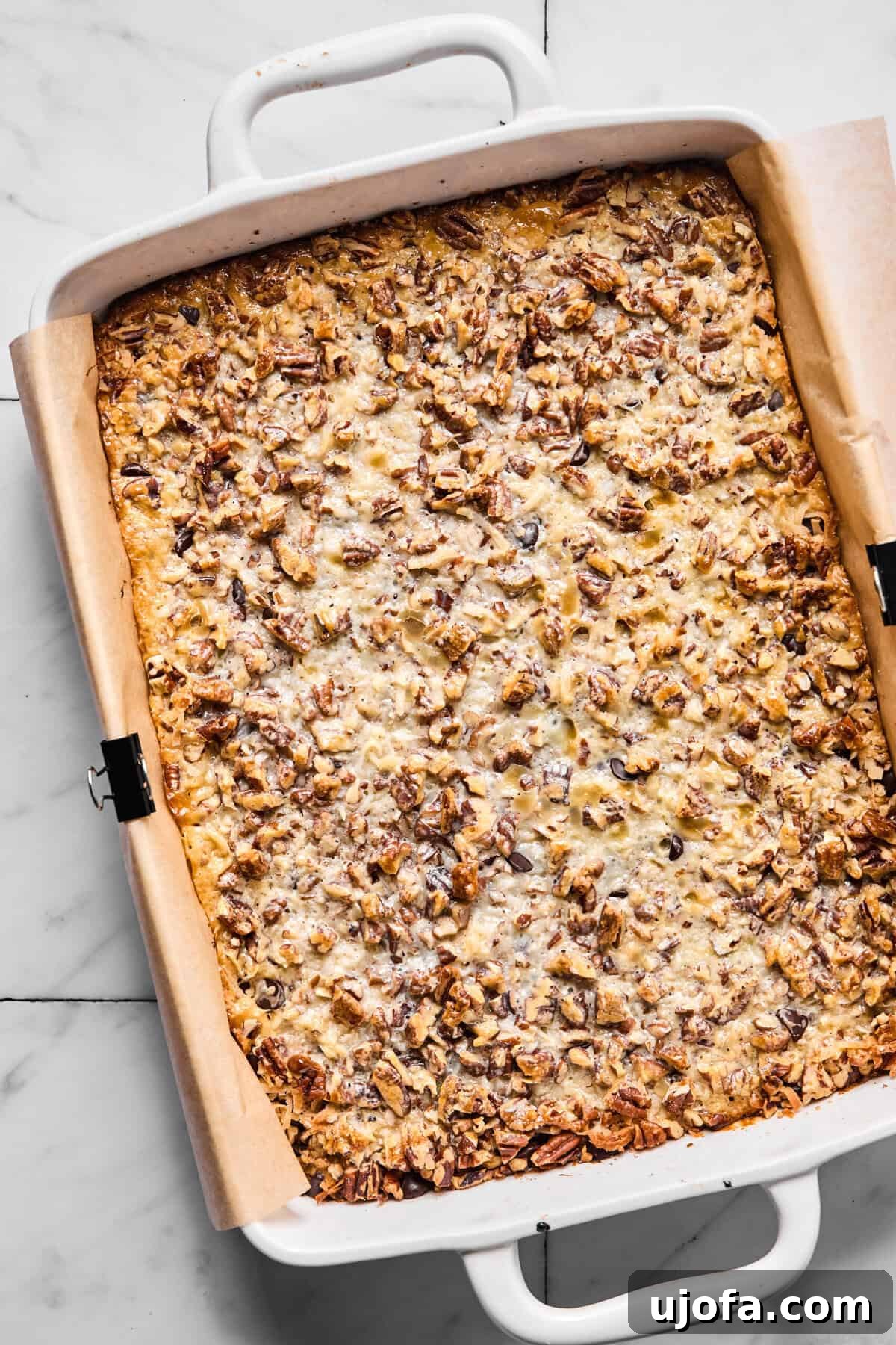 Wondrously Easy Allergen Friendly Bars 9 Fully baked gluten-free magic bars golden and set in the pan before slicing, with toasted coconut visible.
