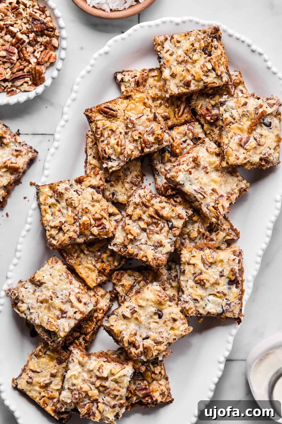 Wondrously Easy Allergen Friendly Bars 10 A serving platter filled with gluten-free magic bar squares, showing the tops with chocolate, coconut, nuts, and sweetened condensed milk layers glistening.