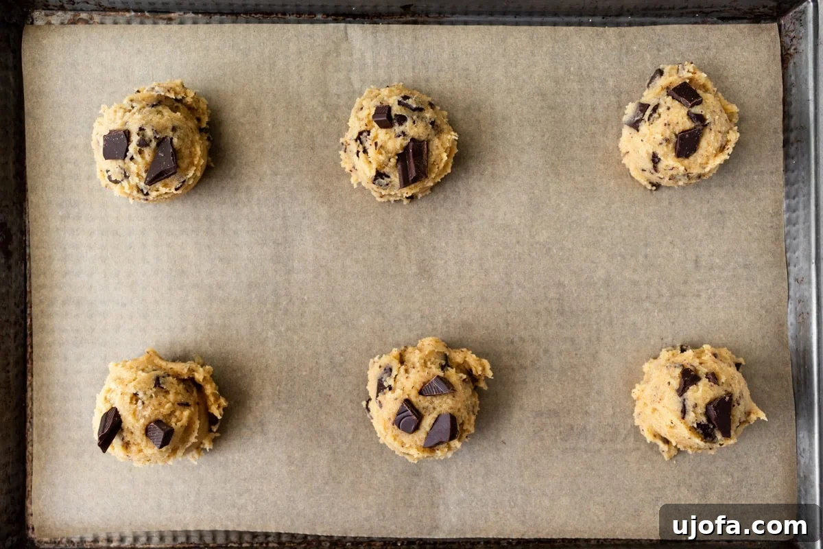 Chewy Coconut Flour Chocolate Chip Cookies 12 Scoops of coconut flour chocolate chip cookies dough on a parchment lined baking sheet