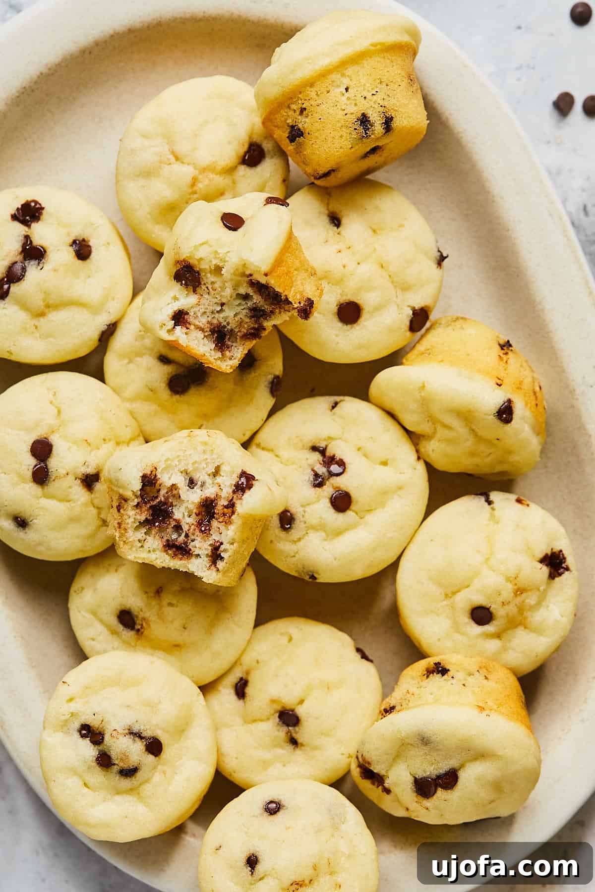 tray of gluten free mini muffins with one cut in half to show the fluffy middle