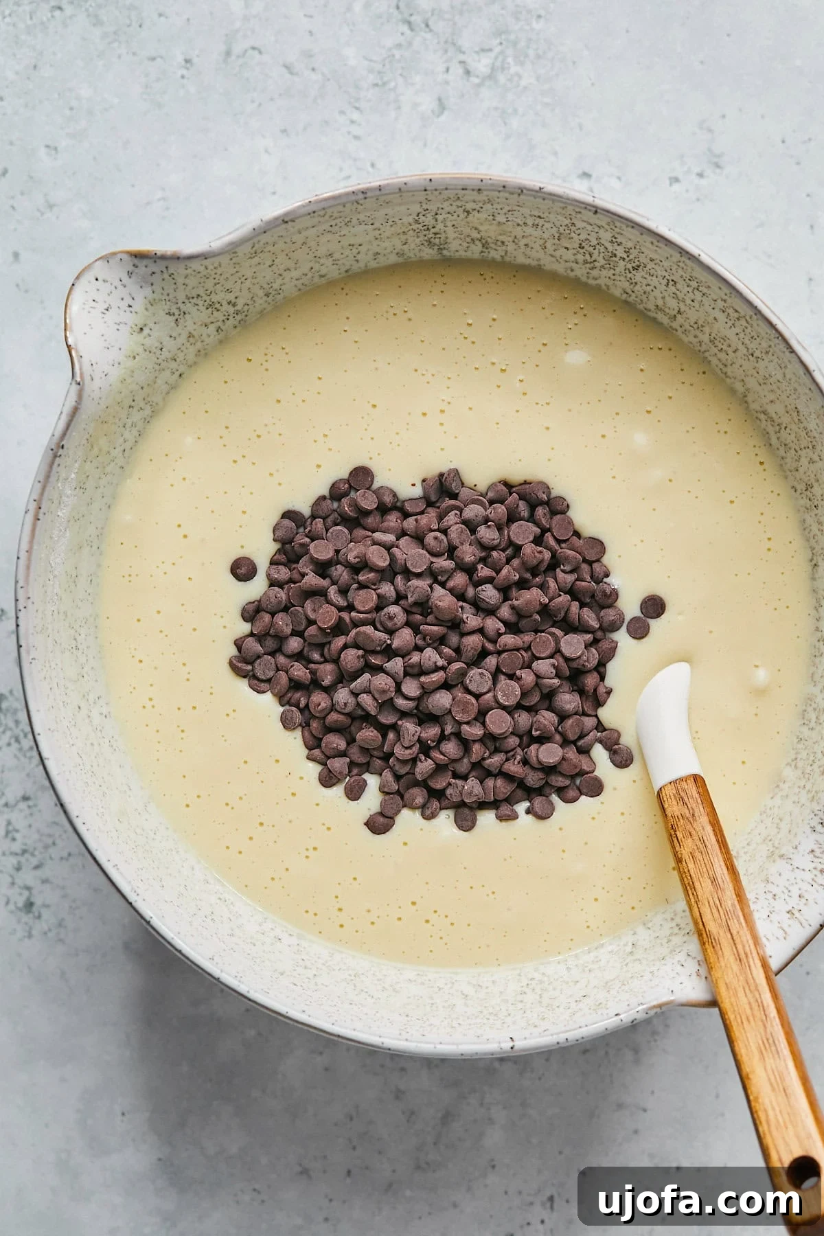 Folding mini chocolate chips into the muffin batter